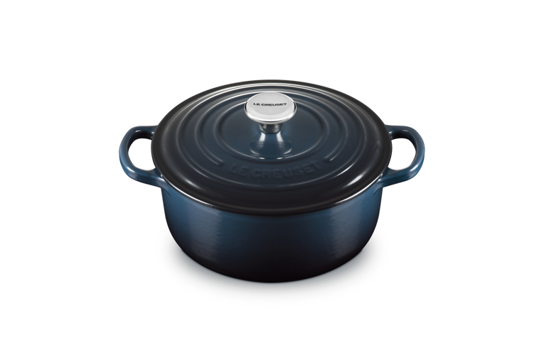 Blue enameled cast iron round Dutch oven with lid on a white background