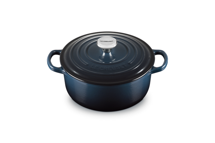 Blue enameled cast iron round Dutch oven with lid on a white background
