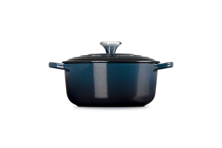 Blue enameled cast iron Dutch oven with lid on a white background