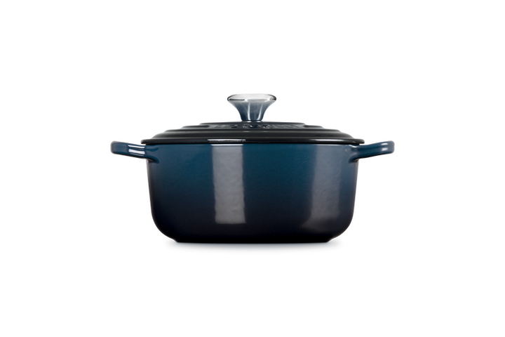 Blue enameled cast iron Dutch oven with lid on a white background