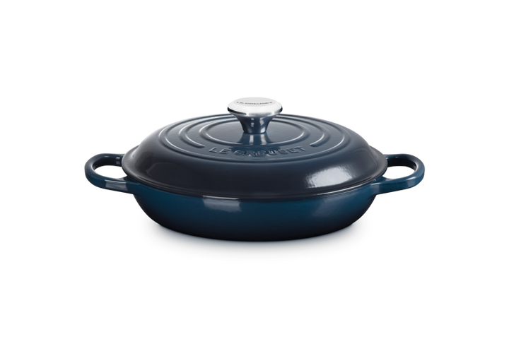 Blue cast iron cookware with lid on a white background