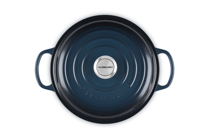 Blue cast iron cookware with Le Creuset logo on a white background