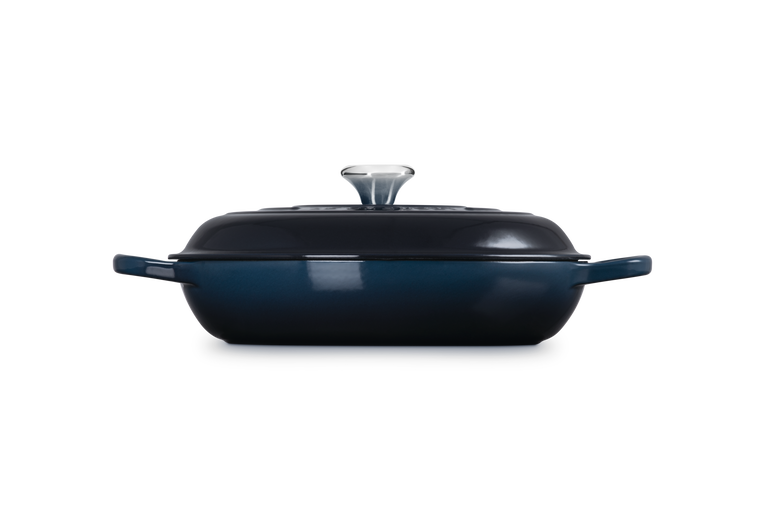 Navy blue oval casserole dish with lid on a white background