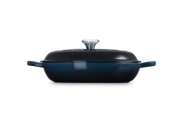 Navy blue oval casserole dish with lid on a white background