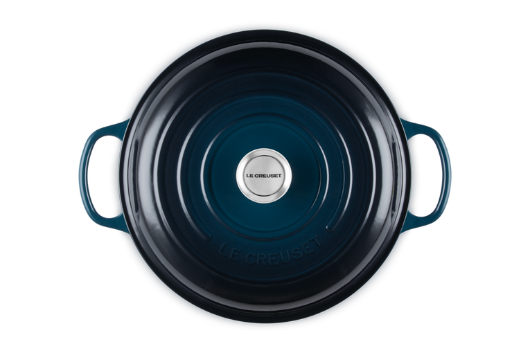 Blue cast iron cookware with Le Creuset logo on a white background