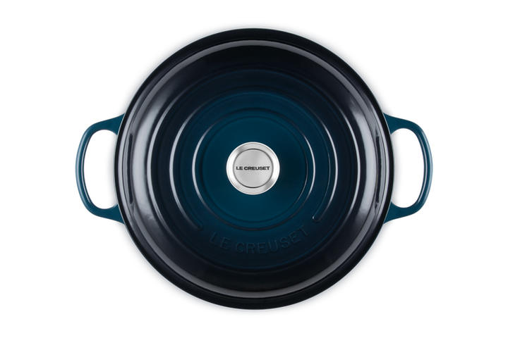 Blue cast iron cookware with Le Creuset logo on a white background