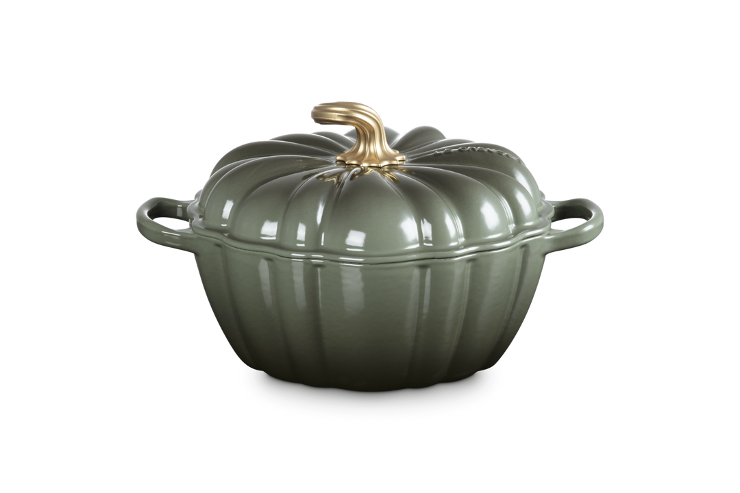 Green ceramic pot with a gold handle on a white background