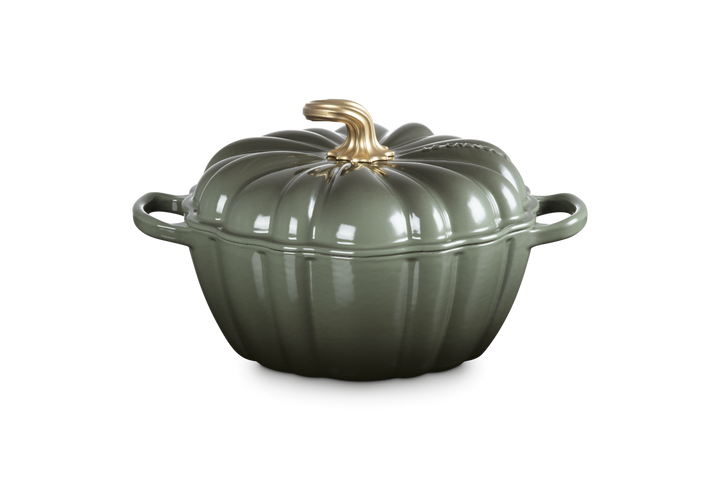 Green ceramic pot with a gold handle on a white background