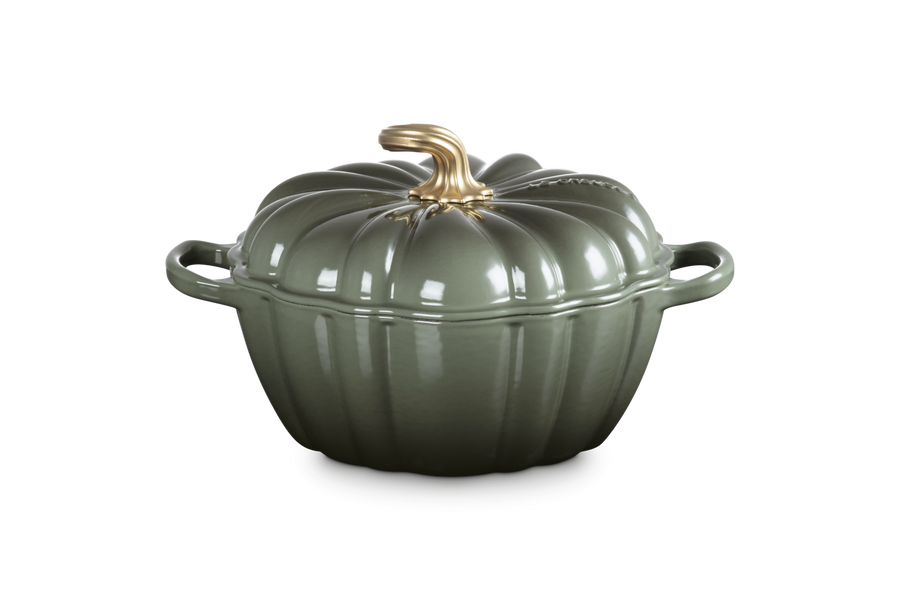 Green ceramic pot with a gold handle on a white background