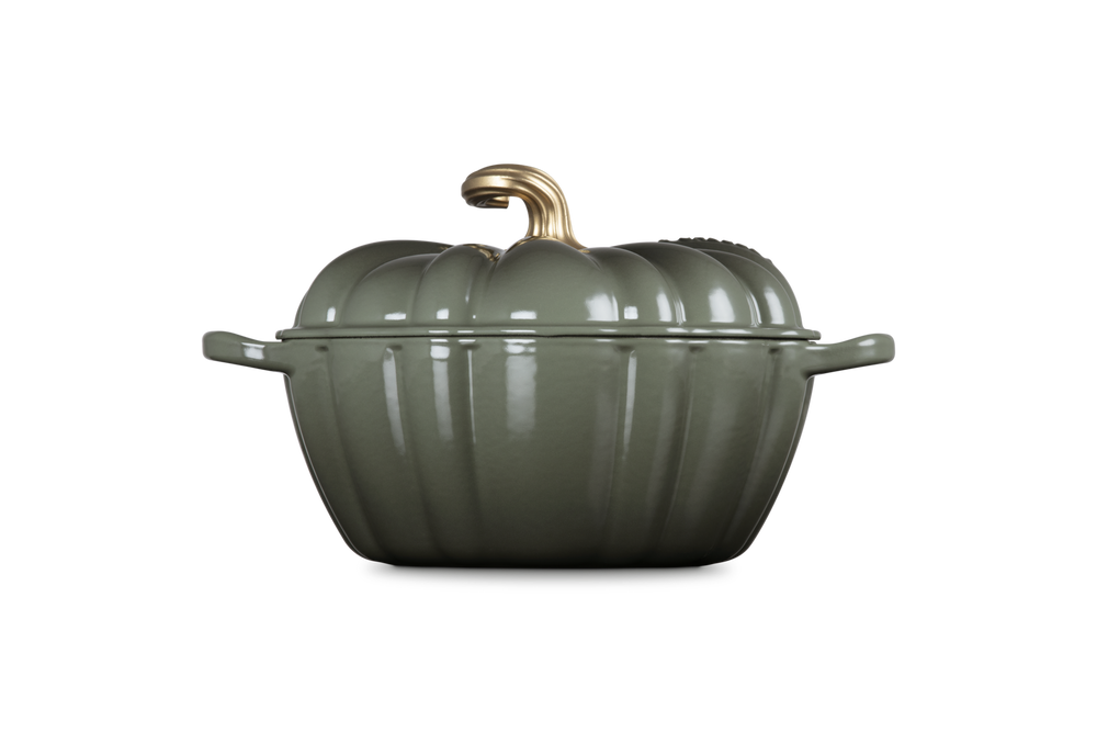 Green pumpkin-shaped cookware with a gold handle on a white background