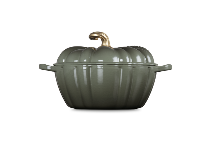 Green pumpkin-shaped cookware with a gold handle on a white background
