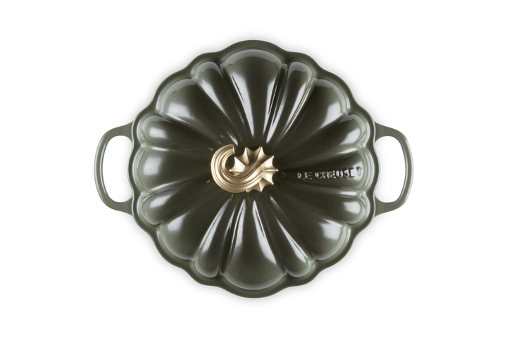 Green pumpkin-shaped baking dish with a gold emblem on a white background