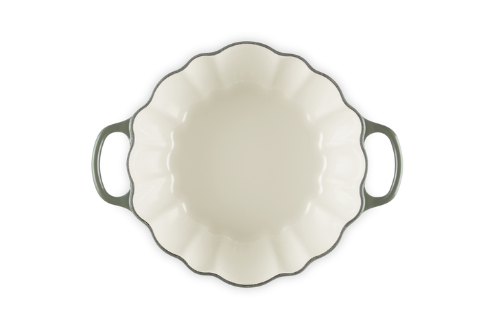 White ceramic pie dish with green handles on a white background