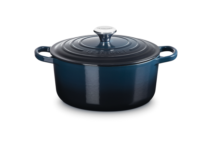 Blue enameled cast iron Dutch oven with lid on a white background