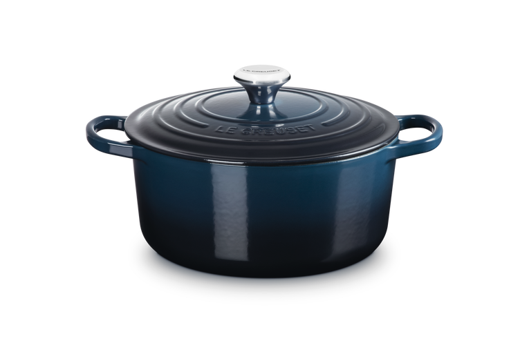 Blue enameled cast iron Dutch oven with lid on a white background