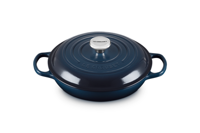 Blue cast iron cookware with a lid on a white background