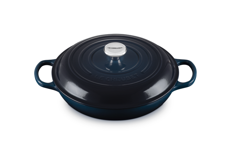 Dark blue enameled cast iron round Dutch oven with handles on a white background