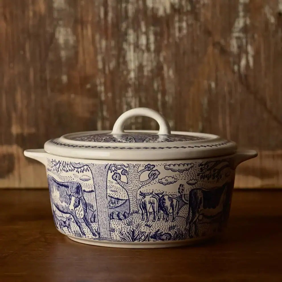 Ceramic cheese baker with blue animal patterns on a wooden surface