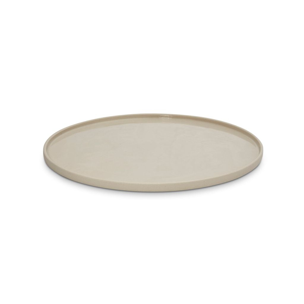 Round beige ceramic plate on a white background
