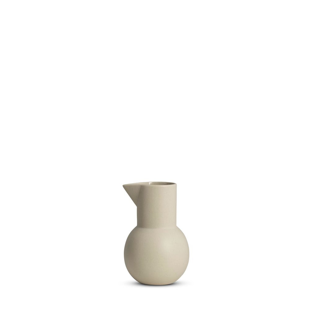 Beige ceramic pitcher on a white background