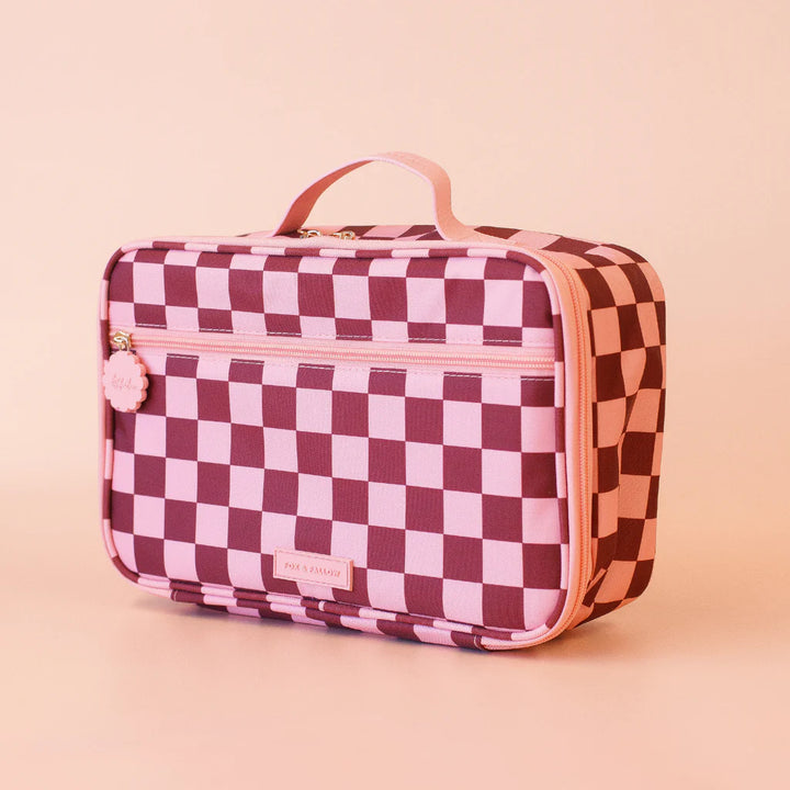Checkered lunch bag with pink handle on a beige background