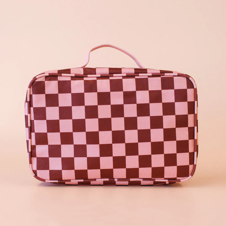 Checkered toiletry bag with pink and brown pattern on a beige background