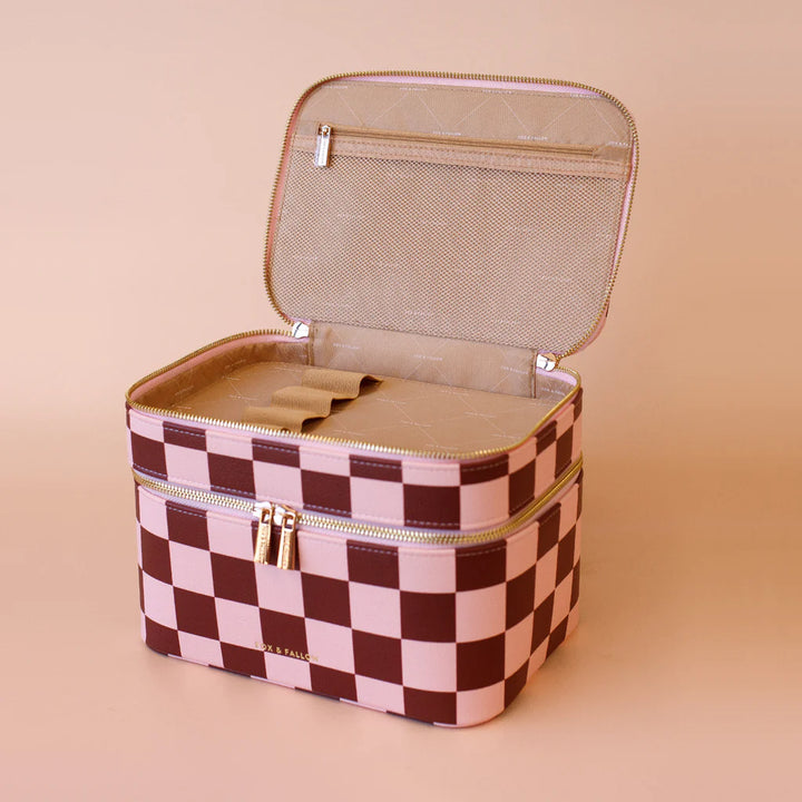 Checkered makeup bag with gold zipper on a beige background