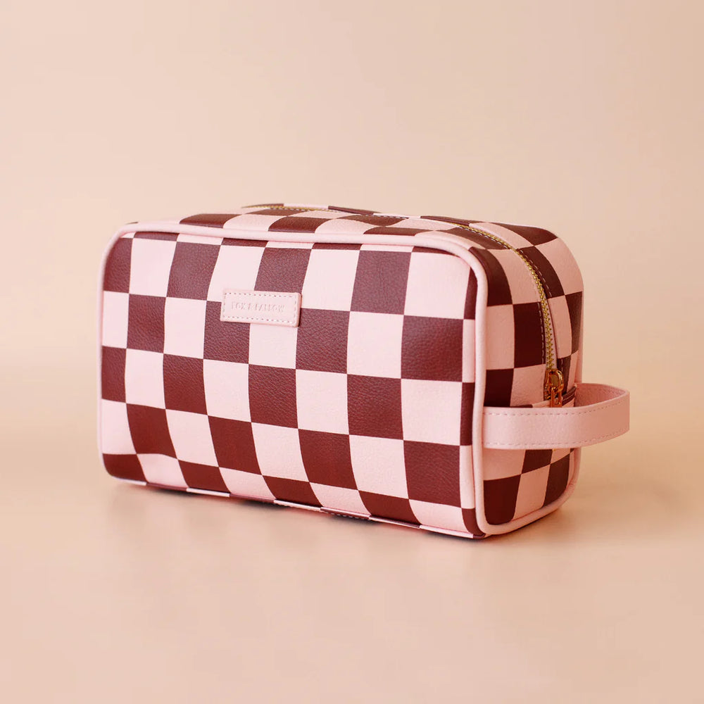 Checkered toiletry bag with a visible brand logo on a beige background