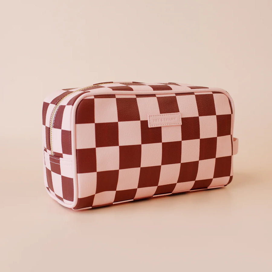 Checkered toiletry bag with a visible brand label on a beige background