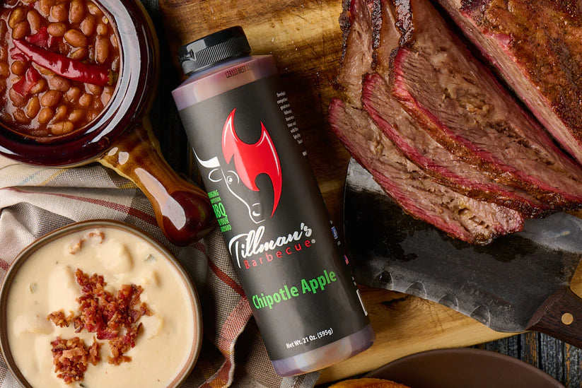 Tillman's Hot Sauce bottle with barbecue ingredients on a wooden board