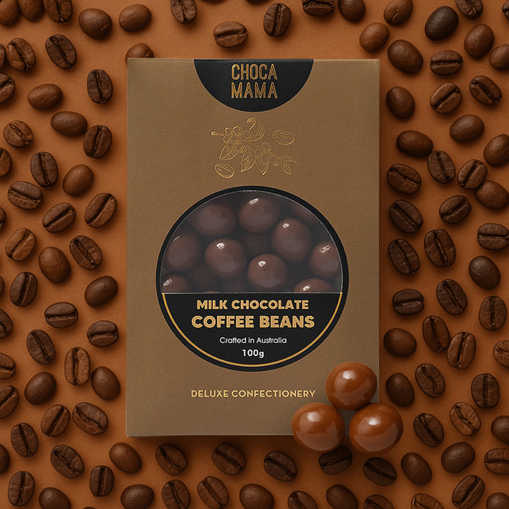 Box of ChocaMama milk chocolate coffee beans surrounded by coffee beans on a brown background