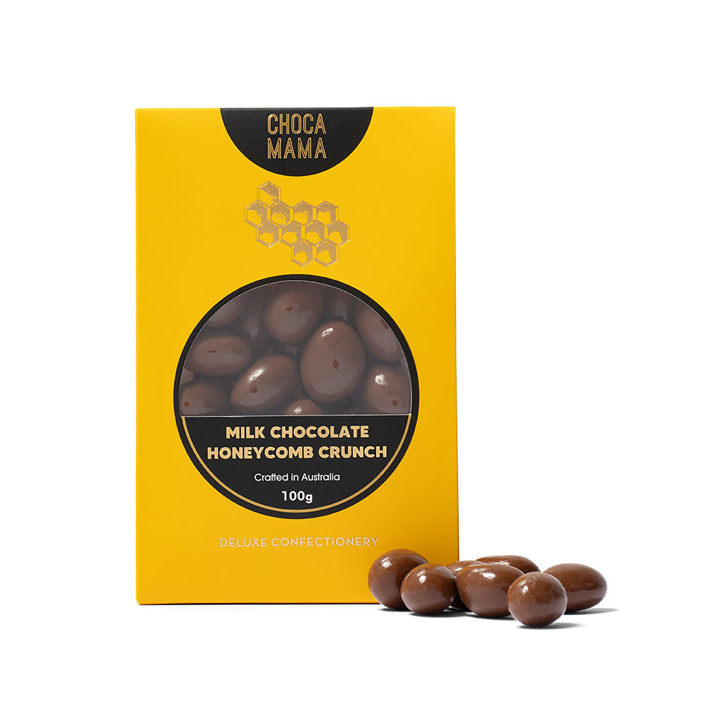 Yellow packaging of ChocaMama milk chocolate honeycomb crunch with chocolate candies on a white background