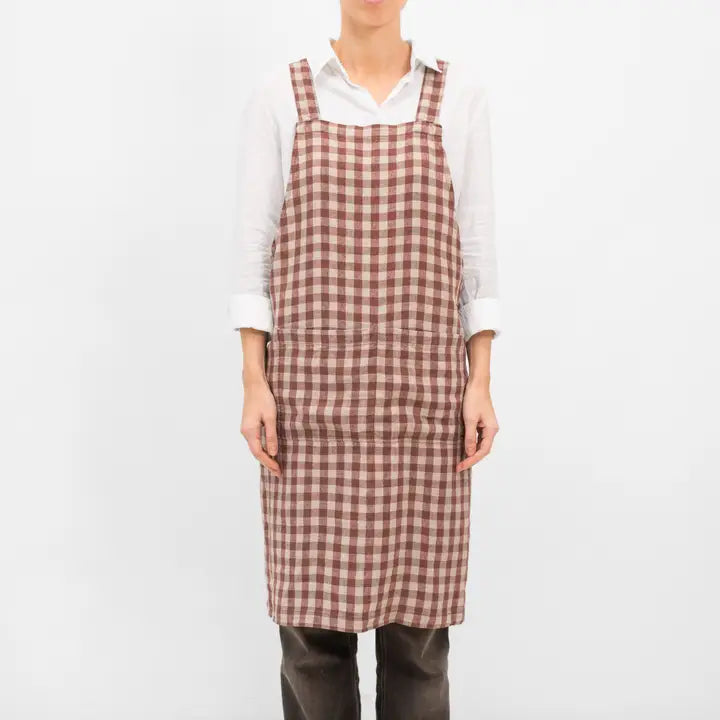 Person wearing a brown checkered apron on a white background
