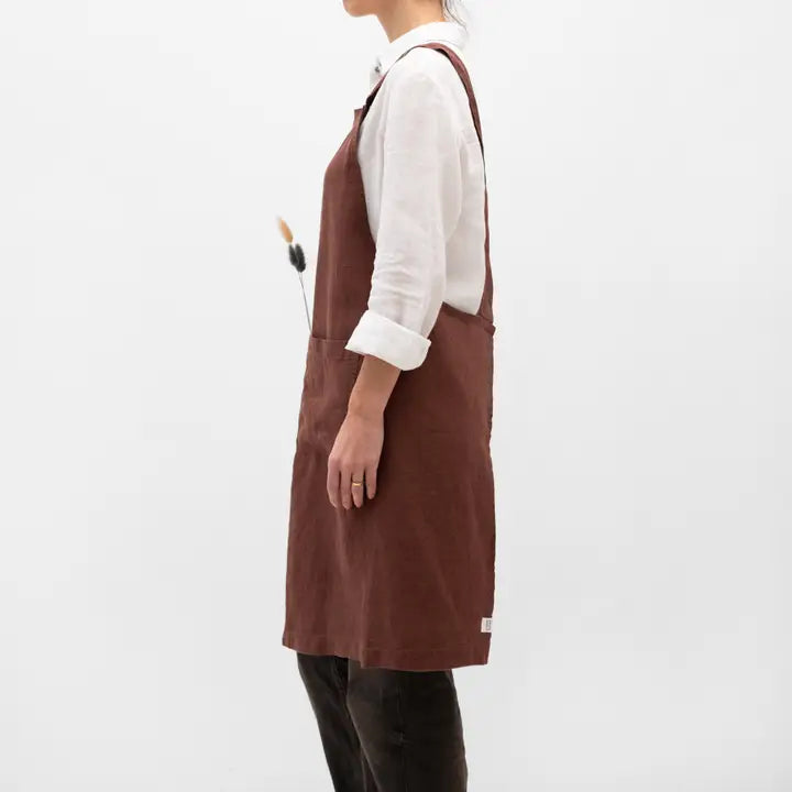 Person wearing a brown apron on a white background