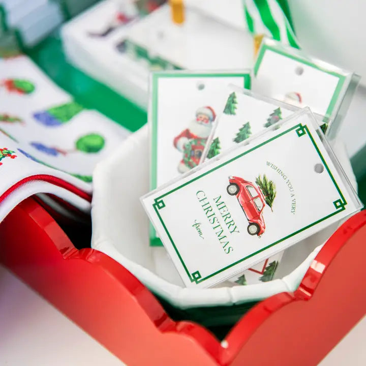 Stack of Christmas-themed cards in a red and white holder