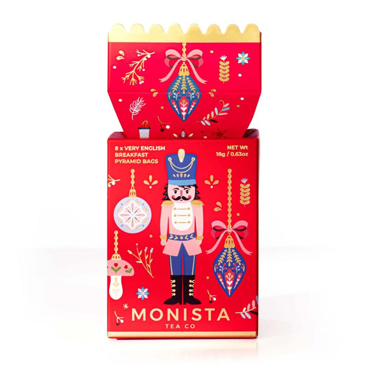 Red Monista Tea Co. packaging with festive designs on a white background