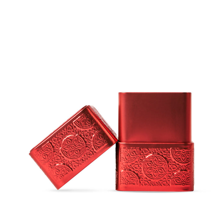 Red metallic tin with intricate patterns on a white background