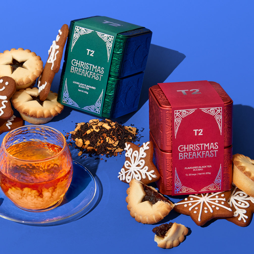 T2 Christmas Breakfast tea boxes with cookies and a glass of tea on a blue background