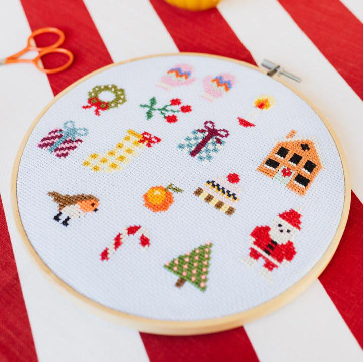 Cross-stitched design on a hoop with a red and white striped background