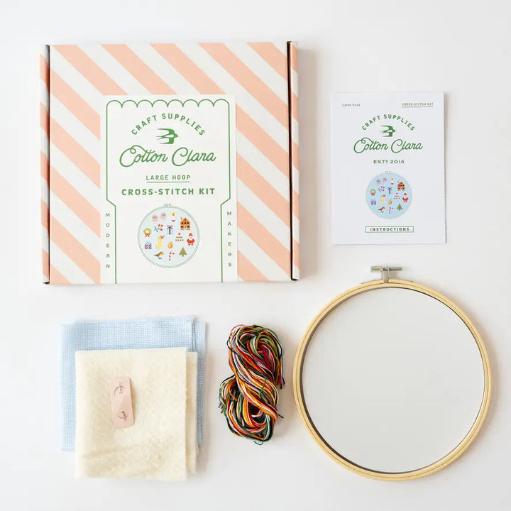 Cross-stitch kit with hoop, yarn, and instructions from Cotton Clara on a white background