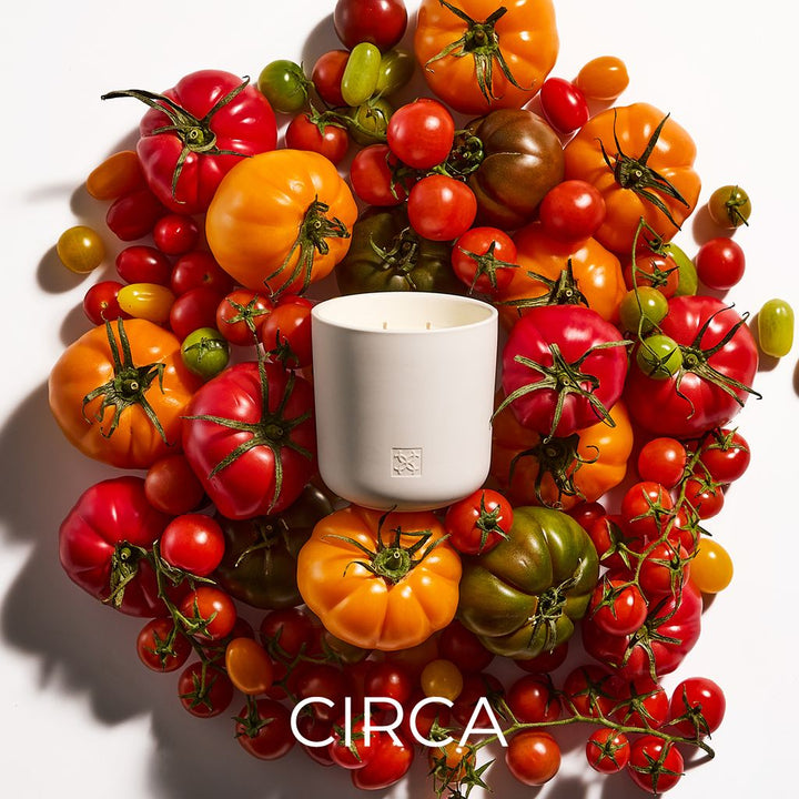 Candle surrounded by a wreath of multicolored tomatoes with &