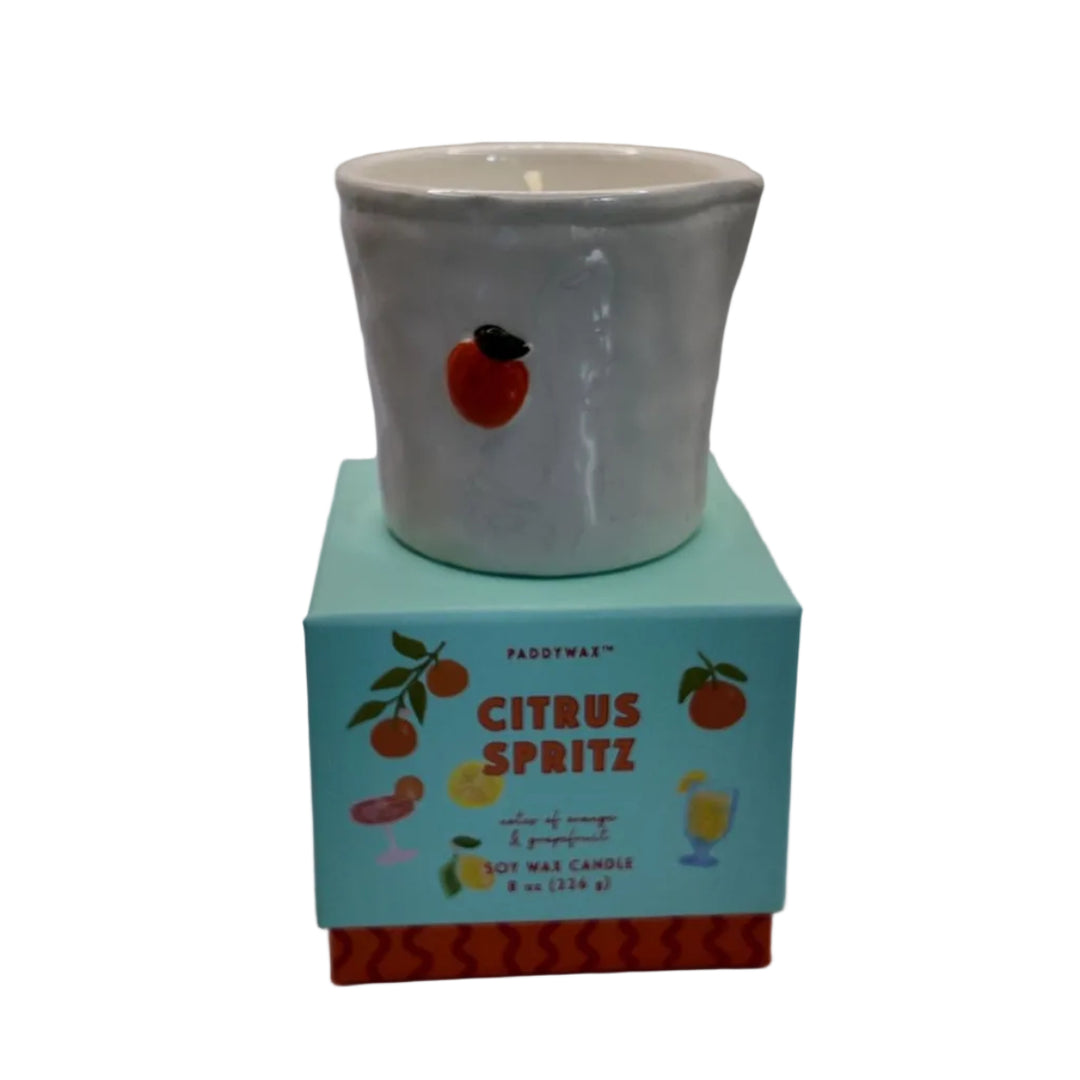 White ceramic vessel candle on a blue box labeled 'Citrus Spritz' against a white background