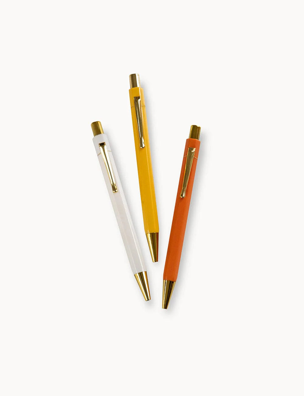 Three pens in white, yellow, and orange on a white background