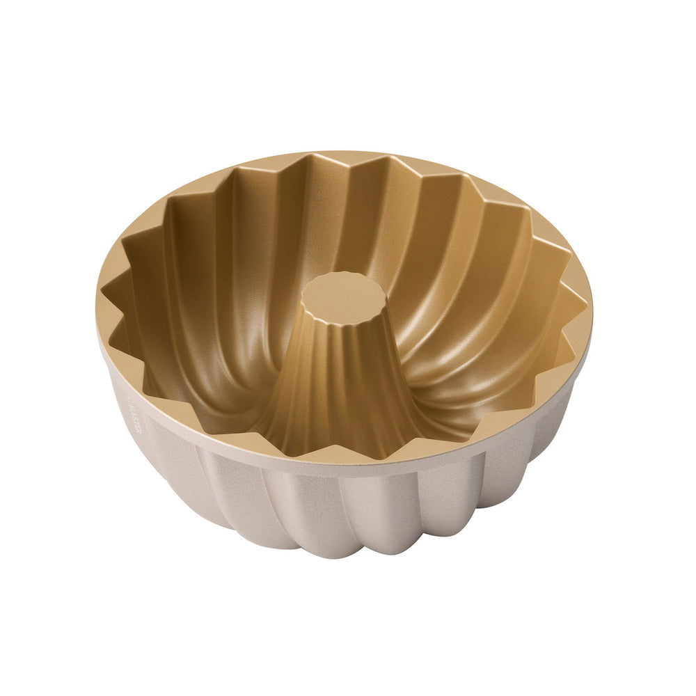 Gold and beige fluted baking mold on a white background