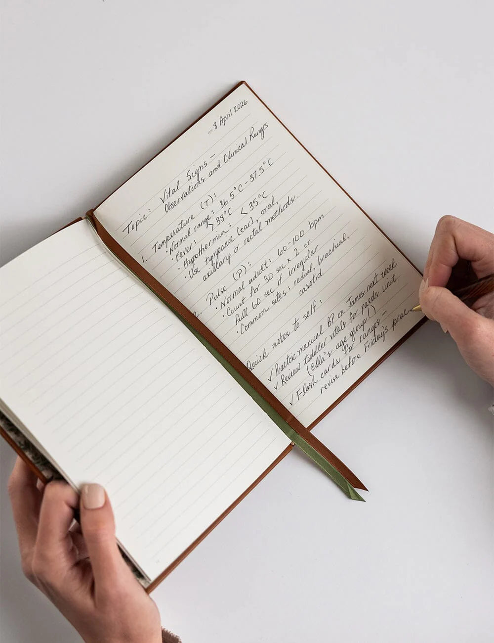 Open notebook with handwritten text on a white surface