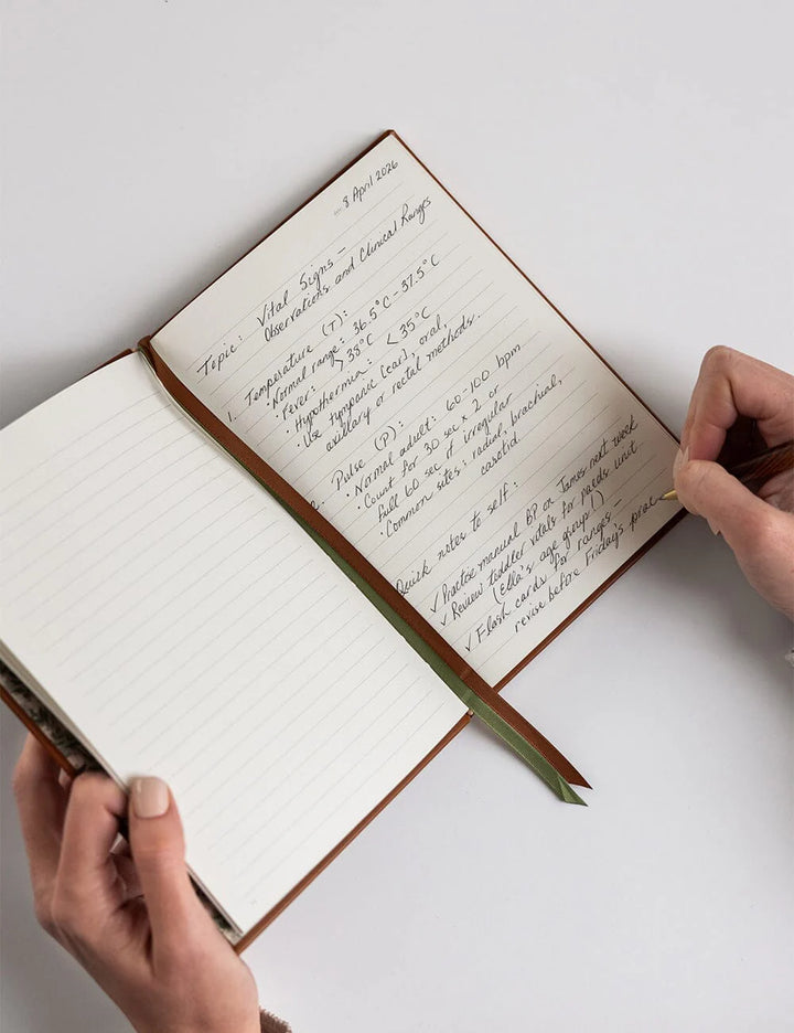 Open notebook with handwritten text on a white surface