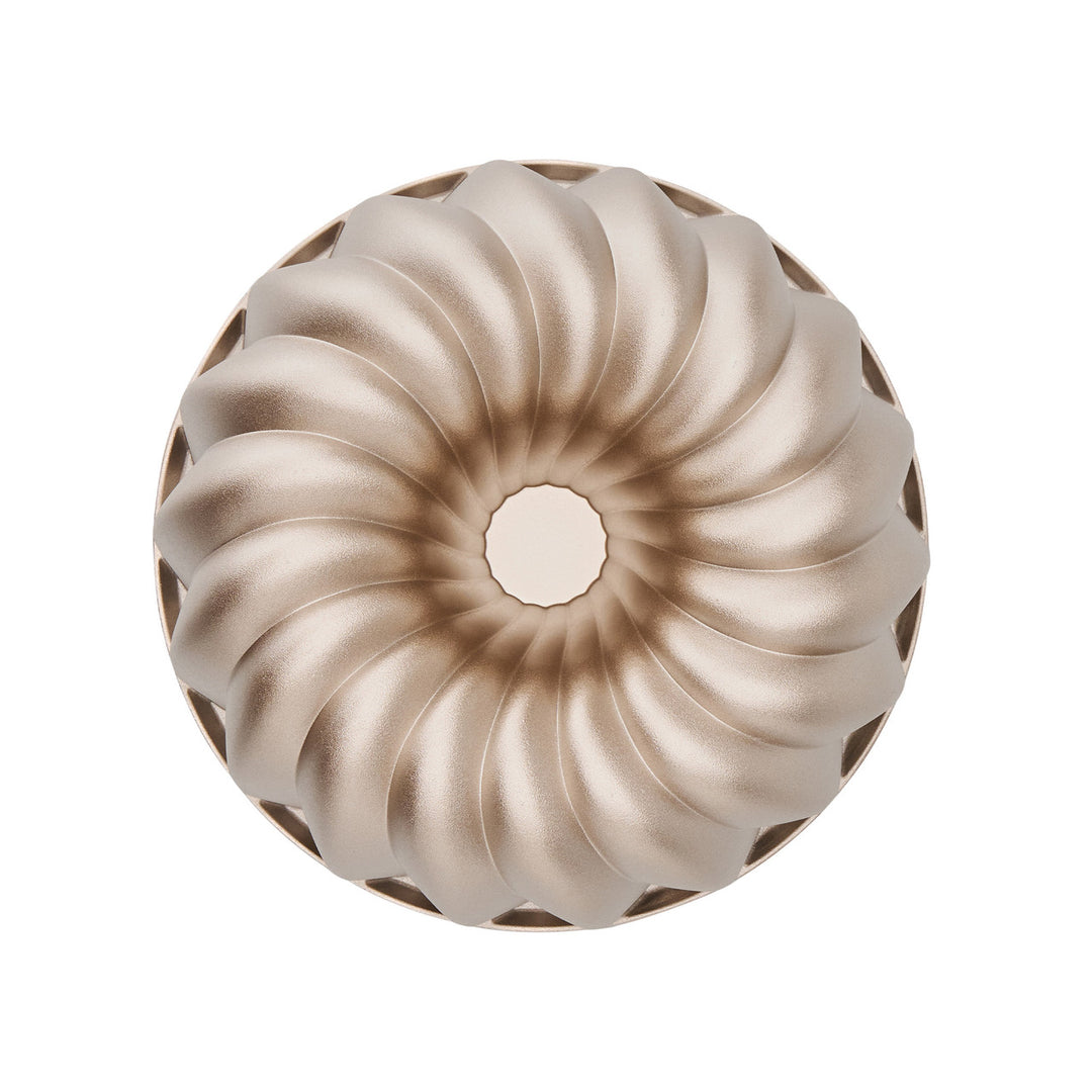 Metallic Bundt cake mold on a white background