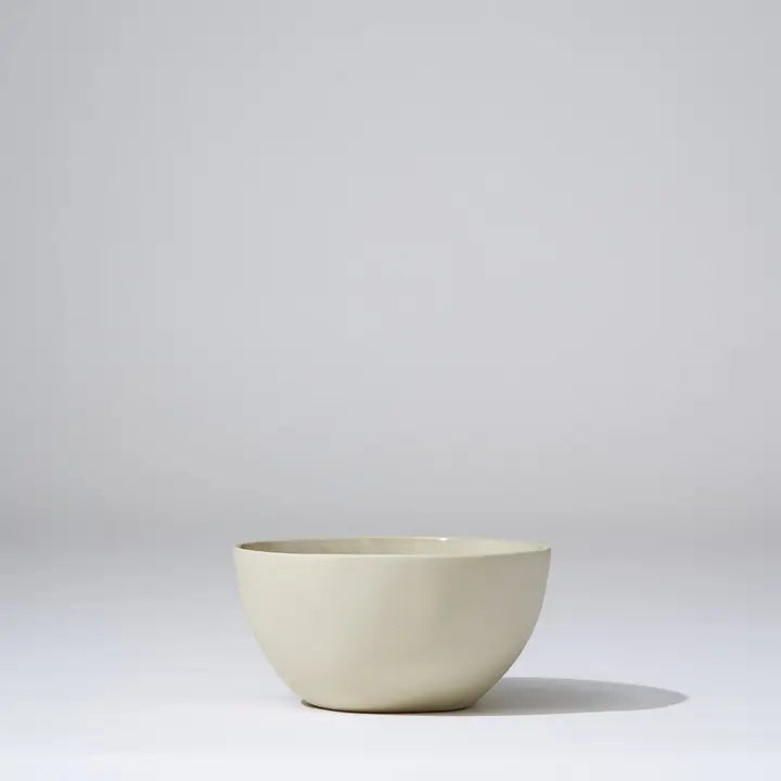 Beige ceramic bowl on a light gray background