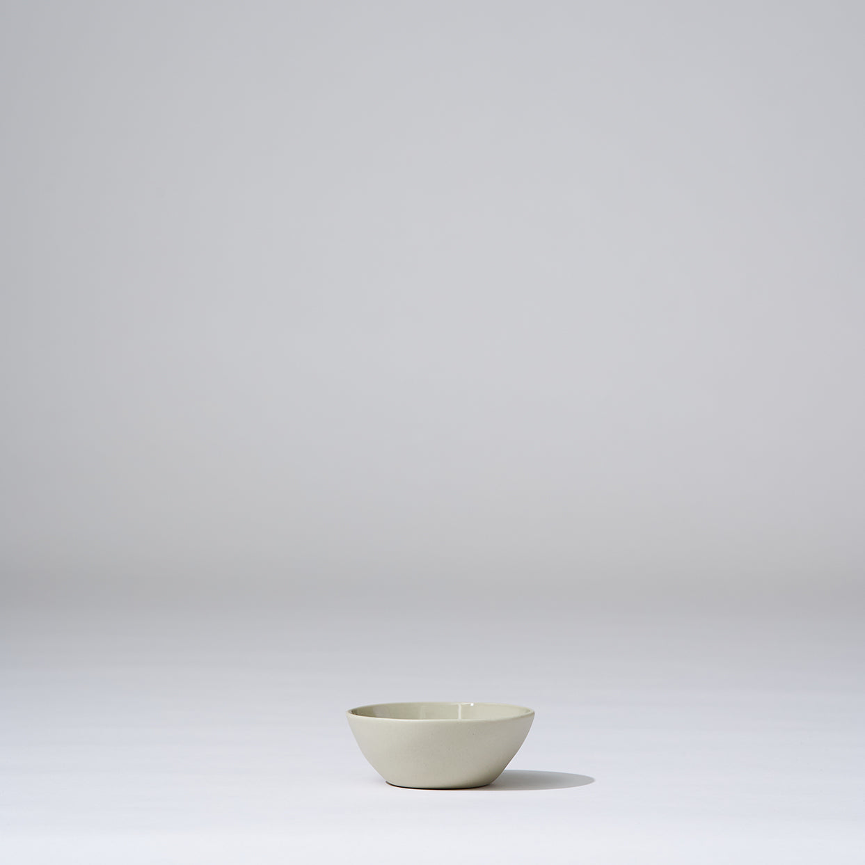 Small white bowl on a light gray background