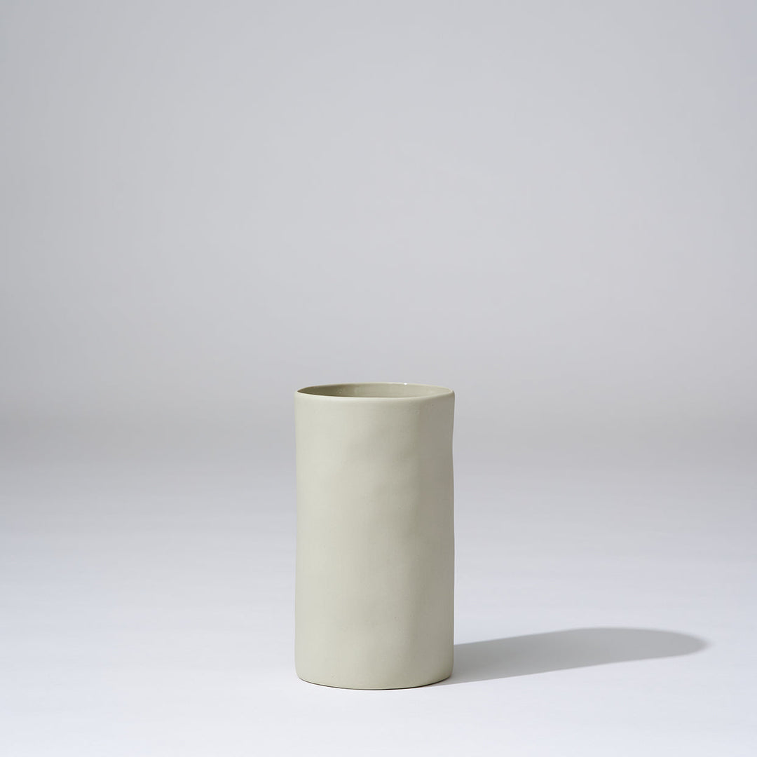 Beige ceramic vase on a light gray background